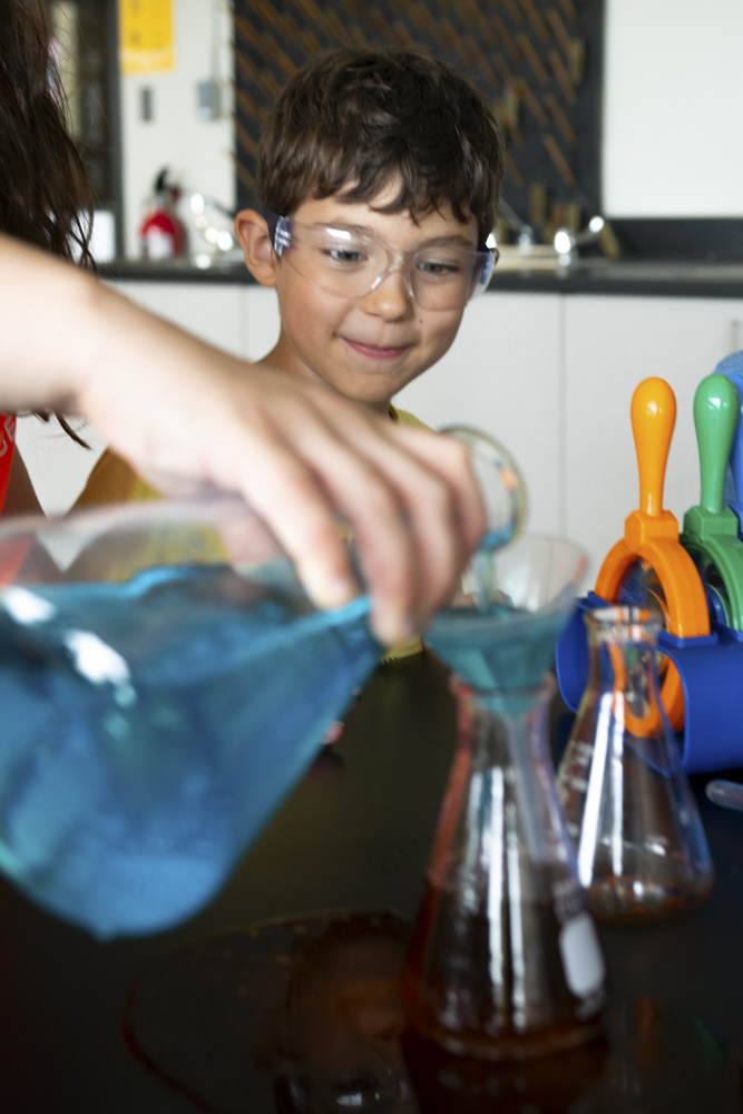 Enfant qui met de l'eau dans un bécher