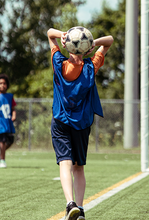 Enfant qui lance un ballon de soccer