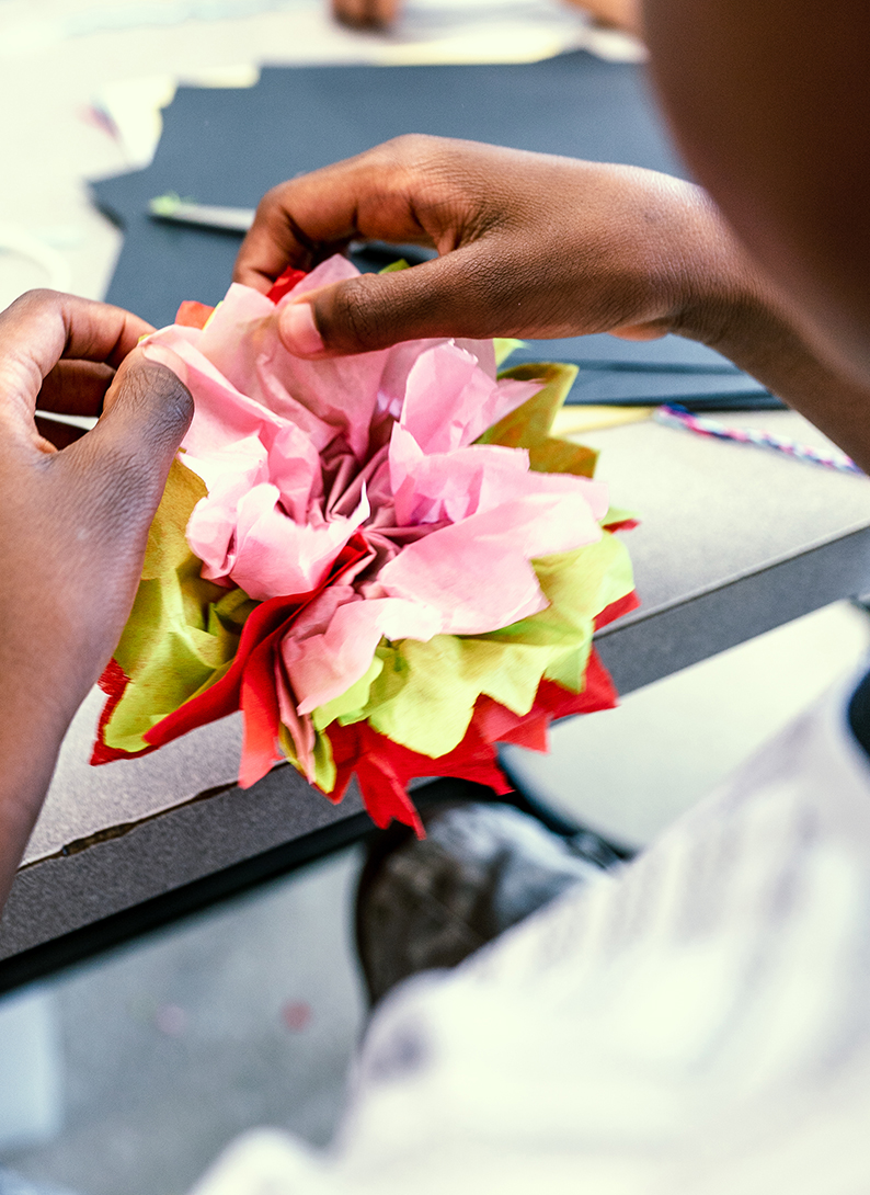 Garçon créant une fleur en papier de soie