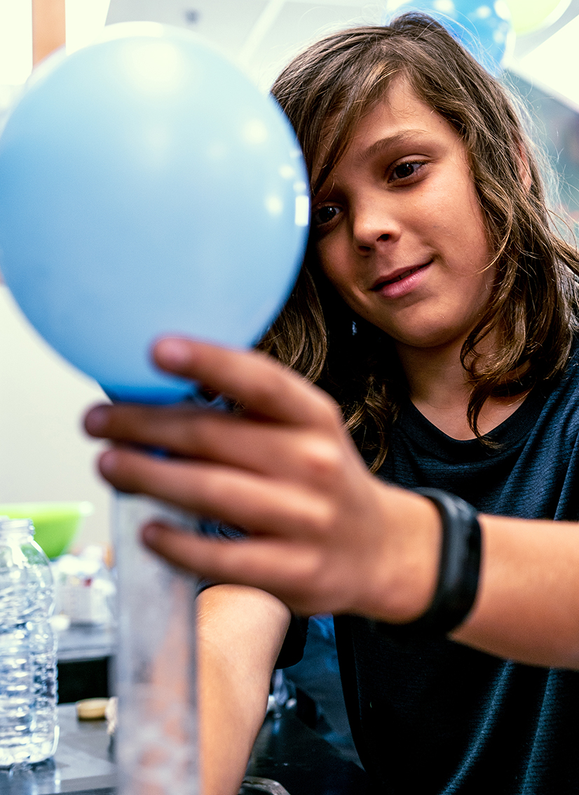Adolescent qui gonfle un ballon avec une expérience