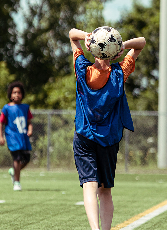 Garçon qui lance un ballon de soccer